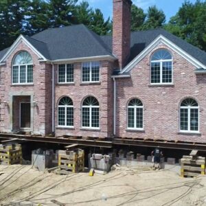 A large brick house lifted by building movers - Payne Construction Services