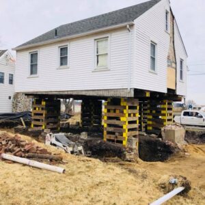 An old house raised above the ground to form a new foundation - Payne Construction Services