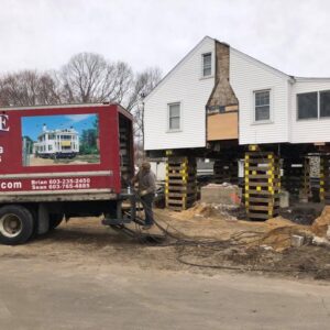 A house lifted above the ground with Payne Construction Services truck