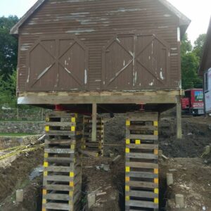 An old barn raised high above the ground with support beams - Payne Construction Services