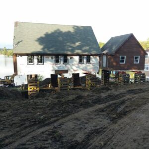 A house and barn by a lake raised above the foundation - Payne Construction Services