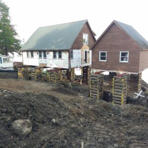 Two buildings raised above the ground for a new foundation - Payne Construction Services