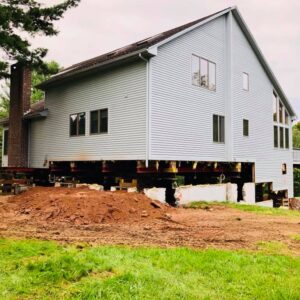 A house lifted up from the foundation by the frame - Payne Construction Services