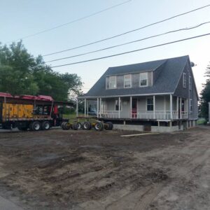 A grey, old house is lifted to create a new foundation.