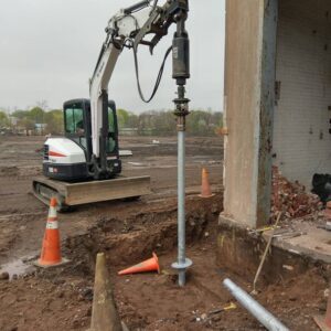 Screwing in a helical pile - Payne Construction Services