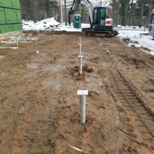 Helical piles screwed into the ground - Payne Construction Services