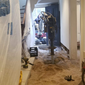 A home's interior dug out so helical piles can be installed - Payne Construction Services