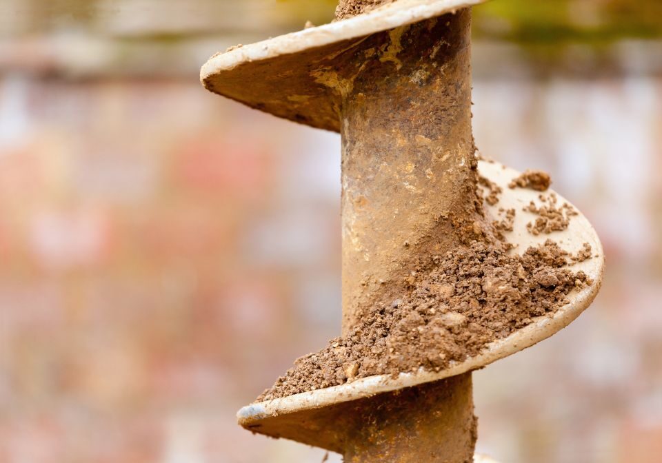 an auger drilling into the dirt