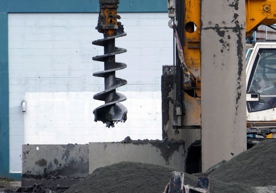 a spiral drill attached to heavy machinery