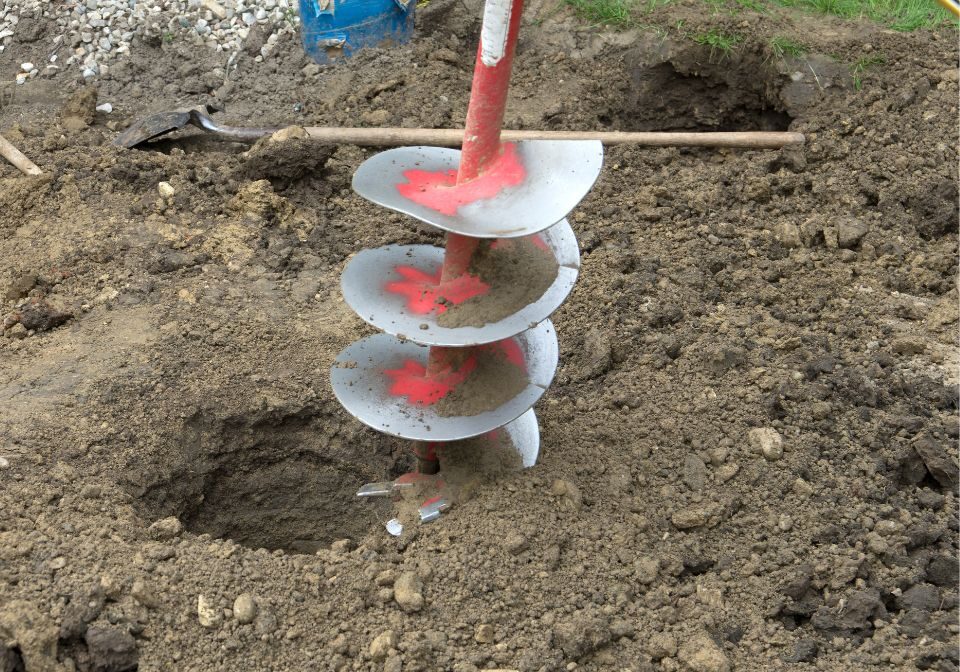 a spiral drill digging up dirt