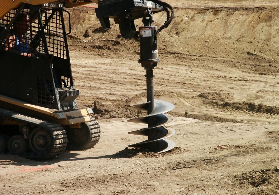 a machine with a spiral drill, drilling the ground